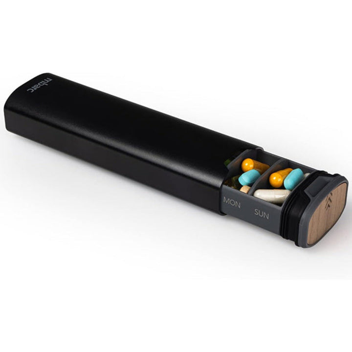 Compact travel pill case featuring a durable aluminum and wood design for 7-day organization.
