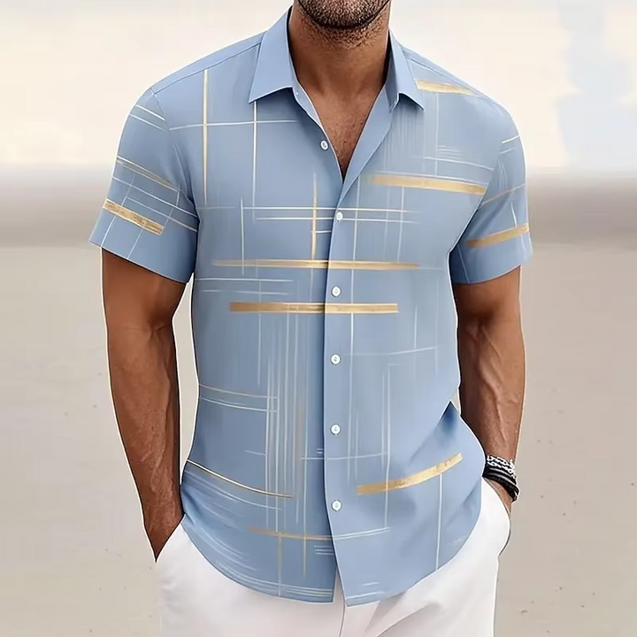 Man wearing a modern patterned short-sleeve button-down shirt, styled for a sleek and casual summer look.