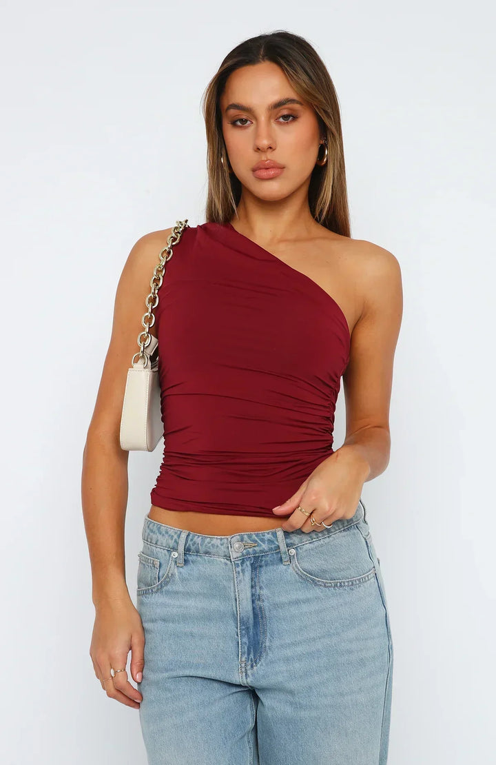 Stylish women's black one shoulder ruched crop top for party wear. Trendy asymmetric summer fashion.