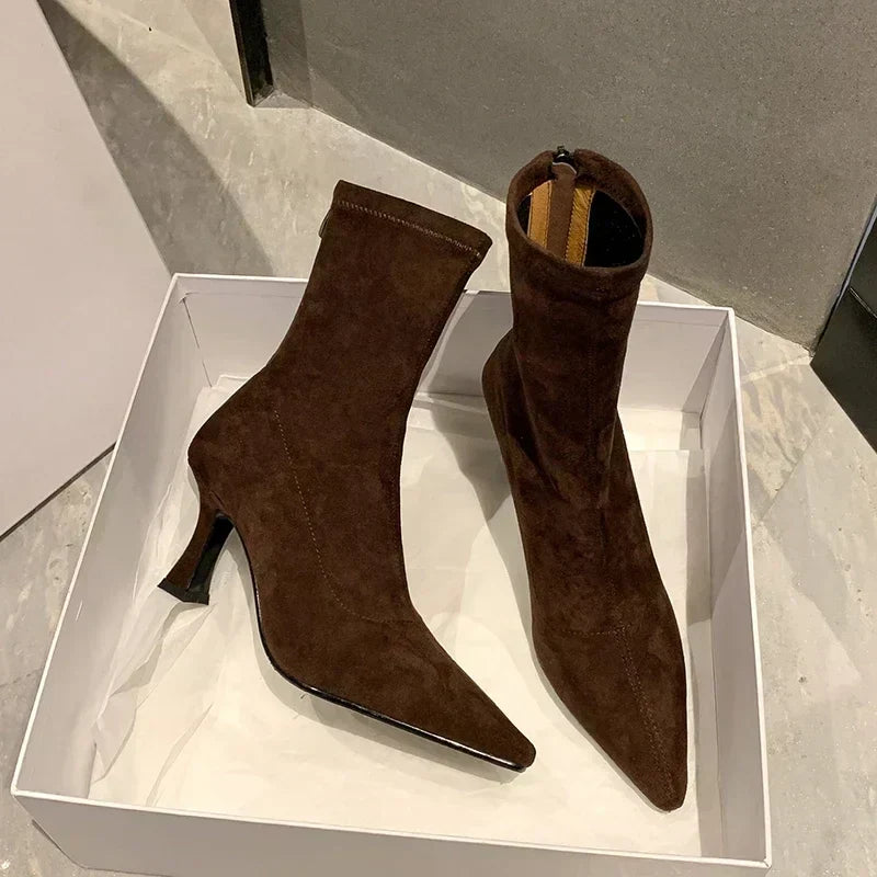 Black women's pointed toe heeled ankle boots, close-up. Mid-heel design, comfortable & chic for everyday style.