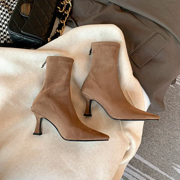 Detail shot: comfortable mid-heel on versatile women's pointed toe ankle boots. Stylish & chic.