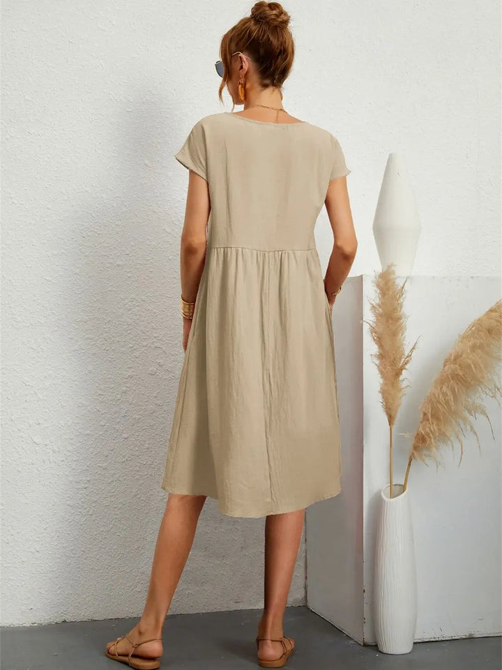 Woman wearing a relaxed fit casual midi dress with pockets, ideal for everyday comfort and style.