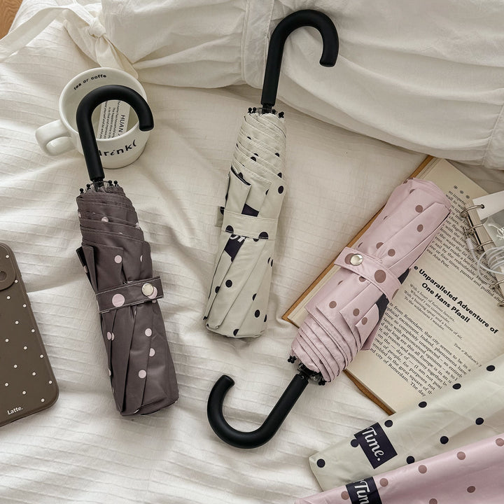 Stylish women's compact folding umbrella for rain protection, portable & waterproof.