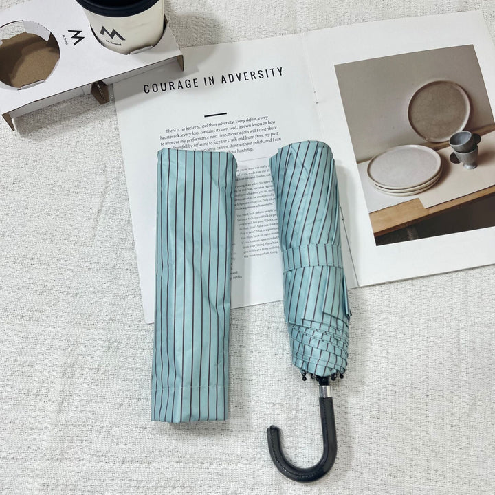 Women's portable rain umbrella, small folding design fits any bag.