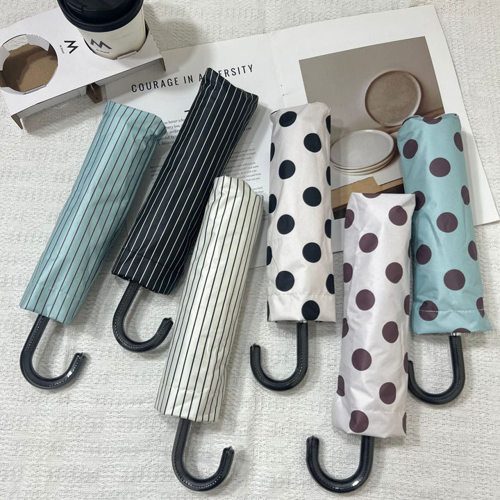 Black polka dot compact travel umbrella for women, strong rain protection.