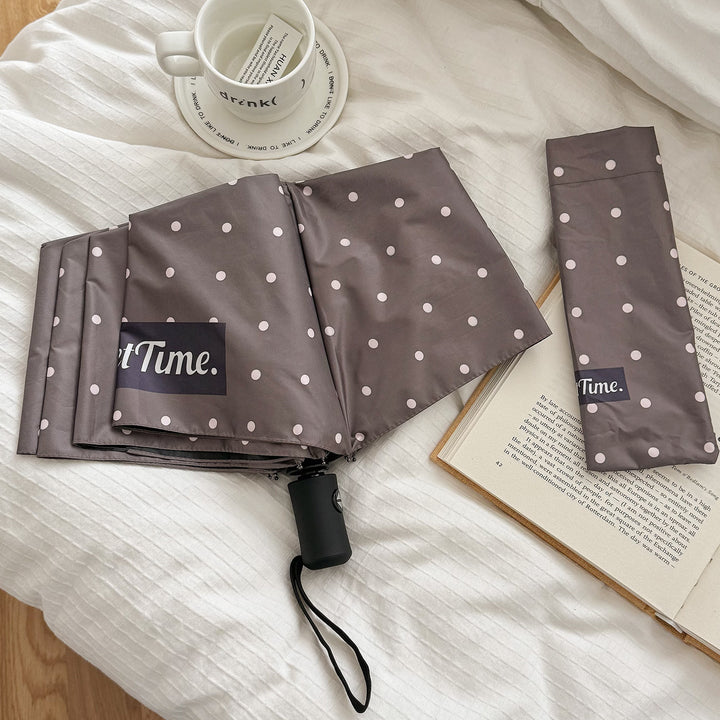 Chic polka dot women's umbrella, compact folding design, great for rain.