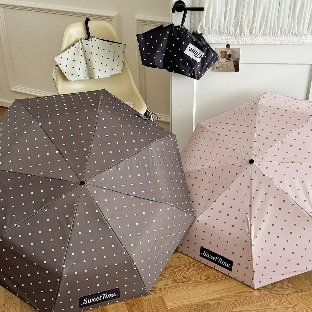 Pink polka dot compact umbrella, women's portable rain protection gear.