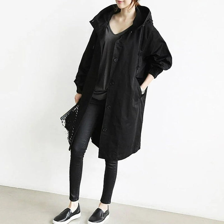 Woman wearing a stylish hooded long rain jacket, perfect lightweight outerwear for casual spring/fall.
