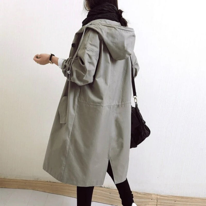 Elegant women's long hooded rain jacket, A-line style, providing weatherproof protection for fashion.