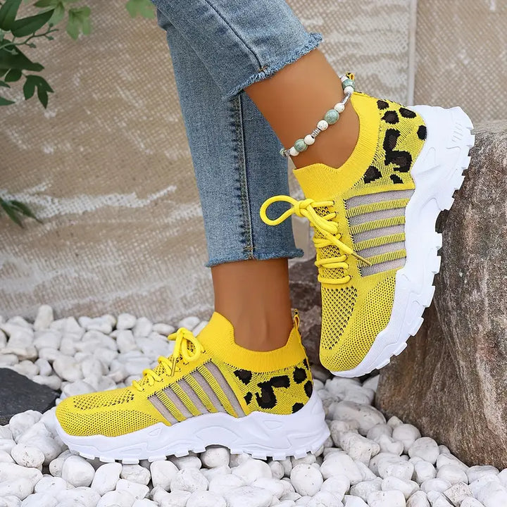Modern women's sneakers with a stylish lace-up design, patterned texture, and rugged lug sole for comfort.