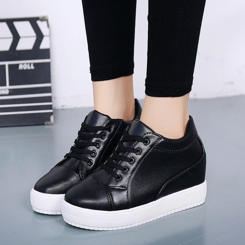 Fashionable women's wedge sneakers. Lace-up platform casual shoes in white or black for comfortable everyday style.
