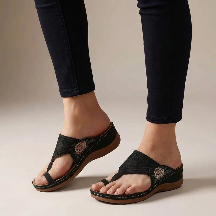 Women's orthopedic comfort wedge sandals. Features floral embroidery & thong design for stylish walk support.