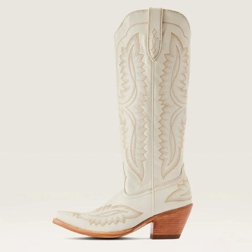 Angled view of chic women's patterned tall boots. Features a sleek pointed toe, stacked heel, and zip closure.