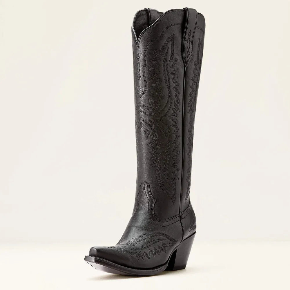 Model walking in stylish women's patterned tall boots. Features stacked heel, zip closure, and elegant design.
