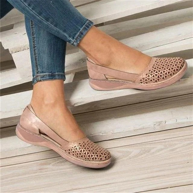 Elegant women's wedge sandals with intricate perforated & cutout details, offering comfortable slip-on summer style.