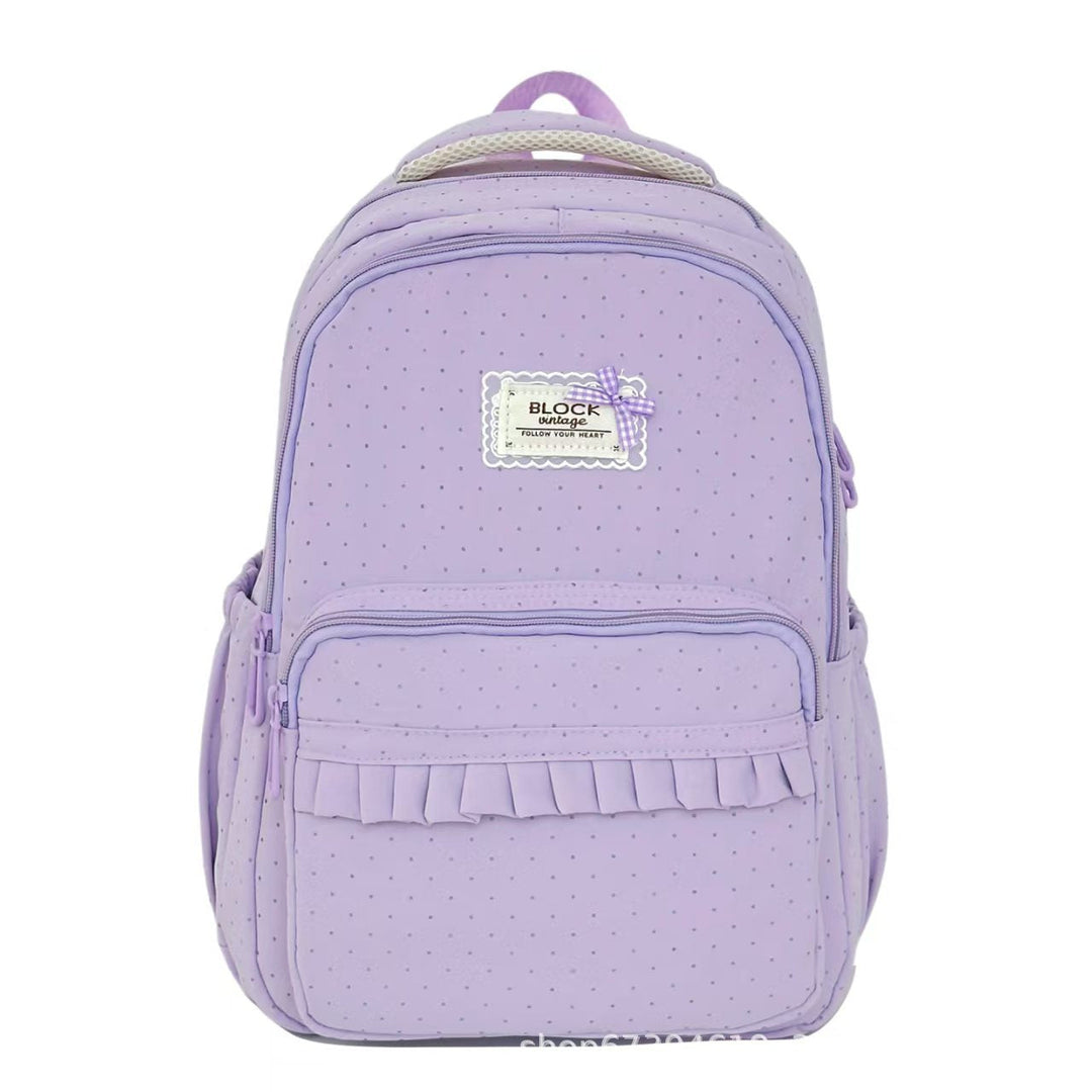 Front view of a women's polka dot ruffled backpack, highlighting chic design, sturdy straps, and practical storage.