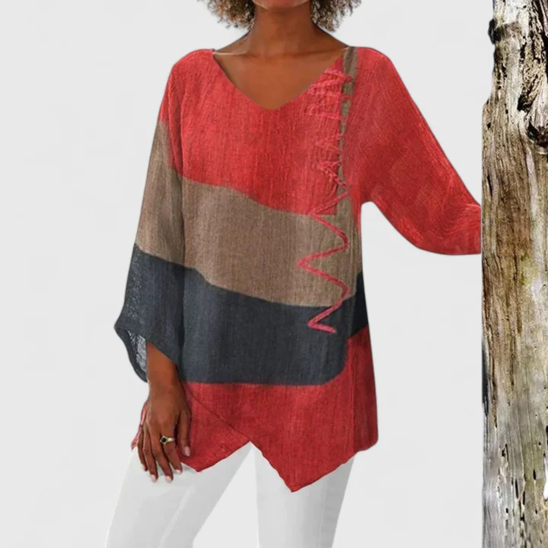 Stylish women's V-neck tunic with colorful artistic print & asymmetrical hem, perfect for casual fashion.