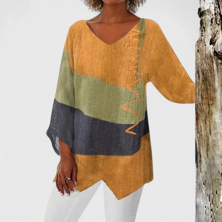 Relaxed fit women's V-neck tunic top featuring a vibrant artistic print and chic asymmetrical hem.