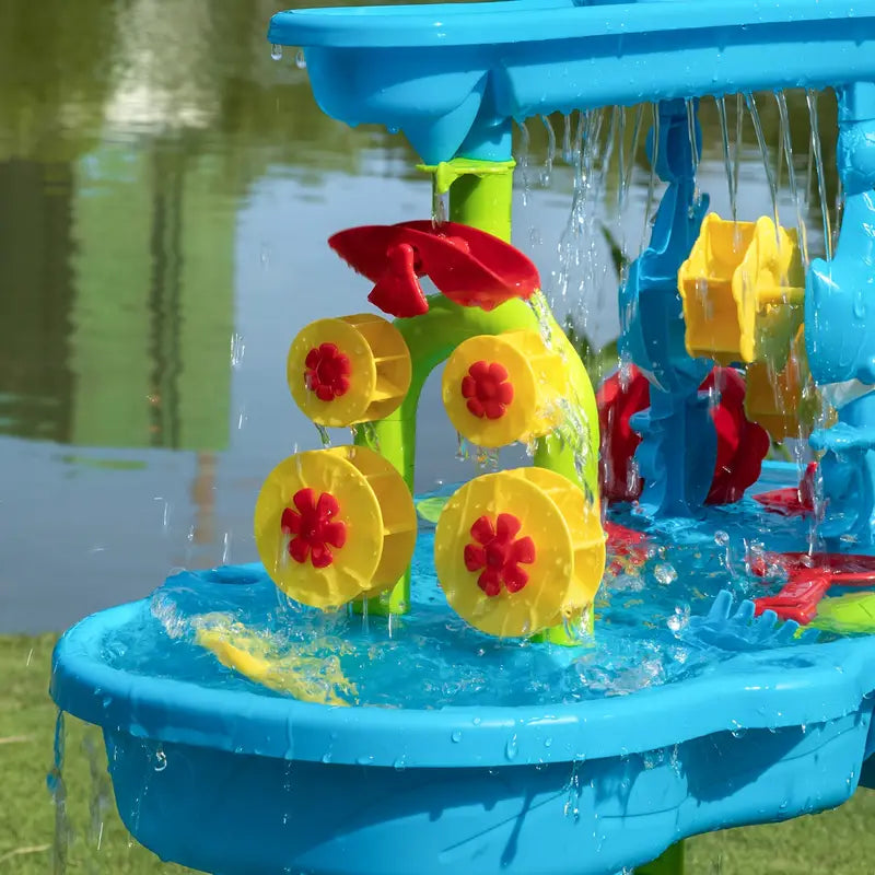 Kids enjoying sensory play with water, toys, and a mini-waterfall feature on an interactive outdoor water table.