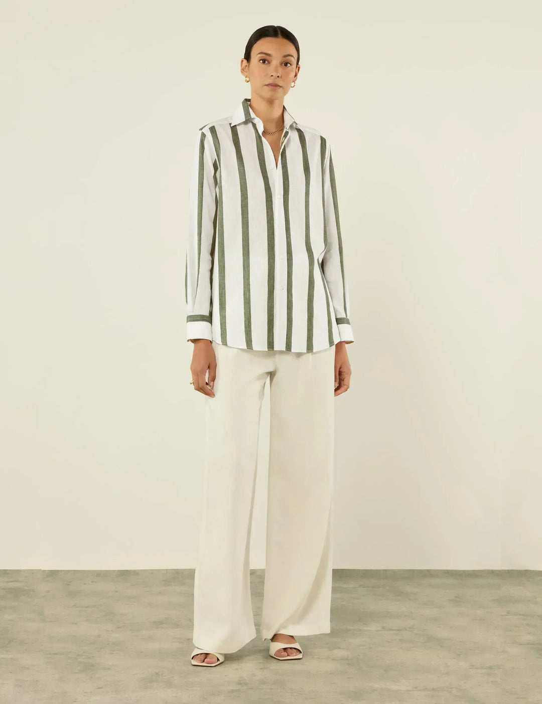 Close-up of a relaxed fit unisex khaki shirt featuring subtle stripes and a classic button-up front.
