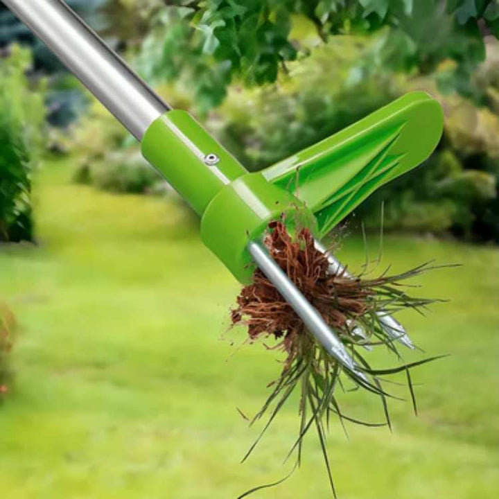 Hand holding RootRipper ergonomic weed puller in a garden, removing dandelions efficiently.
