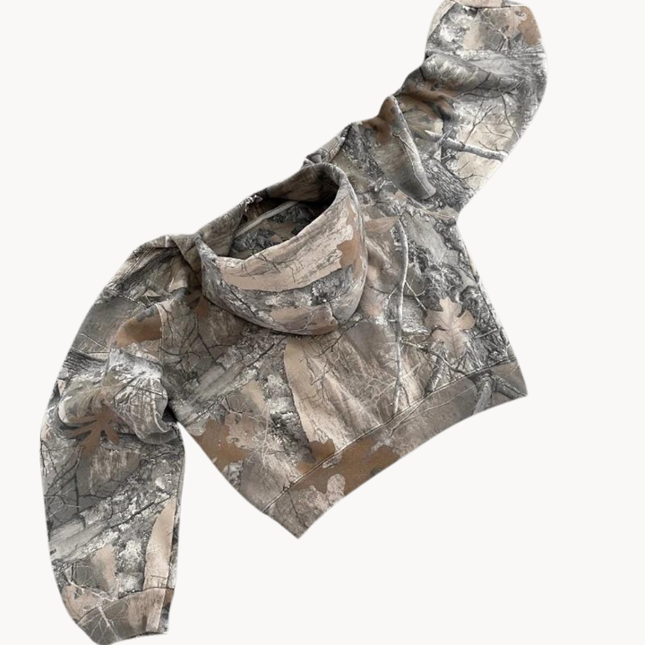 Model wearing an oversized unisex urban camo hoodie, showcasing its relaxed fit & modern streetwear style.