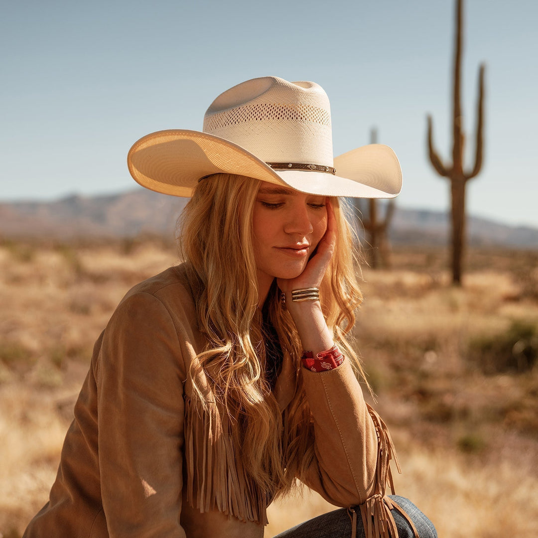 Breathable western cowboy hat featuring a dark leather band & intricate silver accents. Perfect for ranch wear.