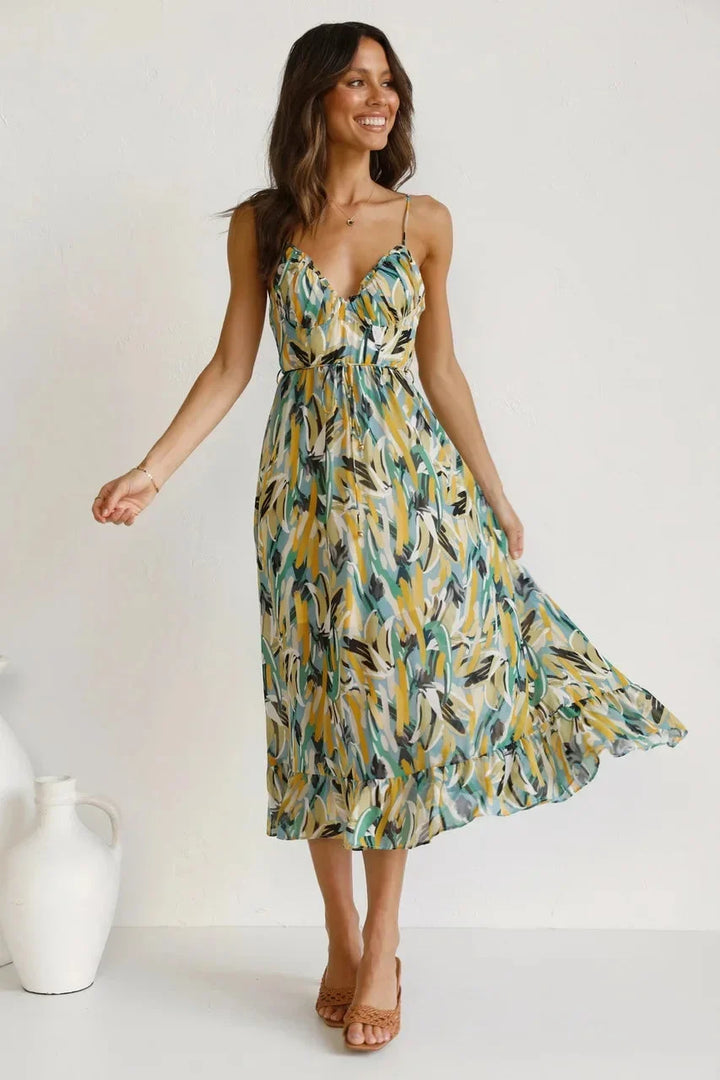 Close-up of vibrant abstract print on a women's flowy v-neck sleeveless midi dress. Trendy summer style fashion.