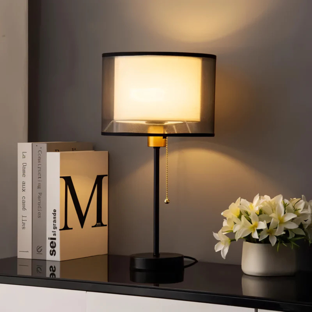 Close-up of vintage table lamp with textured double fabric shade for cozy lighting.