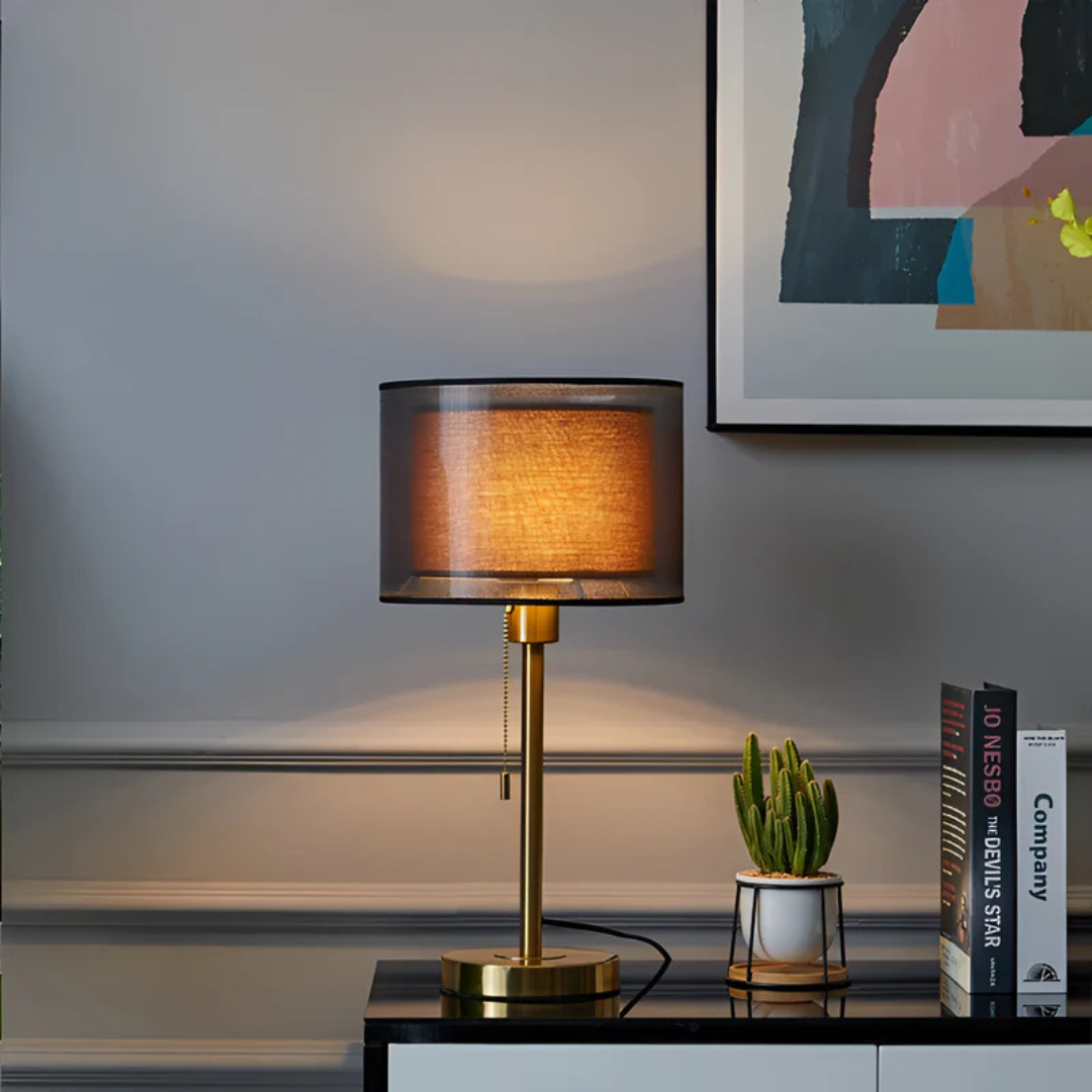 Decorative vintage table lamp with black and bronze accents and a dual fabric shade.