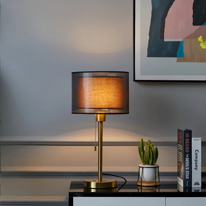 Decorative vintage table lamp with black and bronze accents and a dual fabric shade.