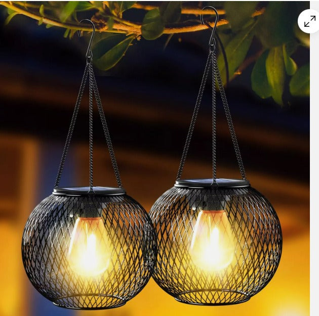 Decorative solar garden lantern with vintage LED light, black metal cage for charming patio ambiance.