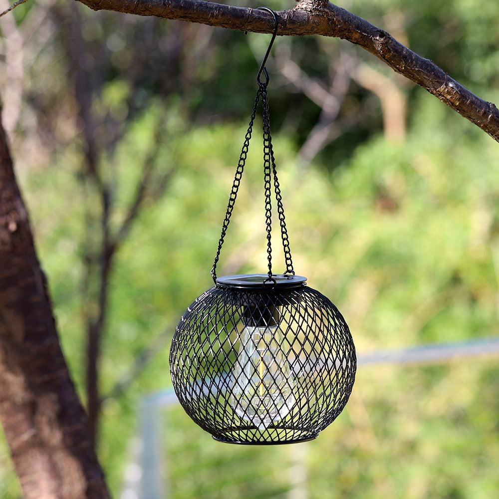 Hanging outdoor solar lantern, vintage LED filament, waterproof metal cage for garden & patio lighting.