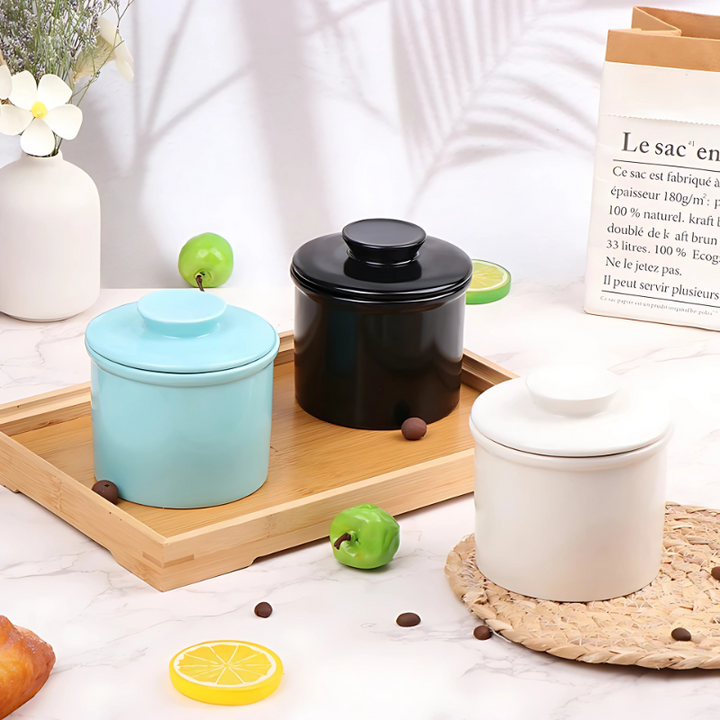 White ceramic butter keeper, water-sealed for fresh, spreadable butter on a kitchen countertop.