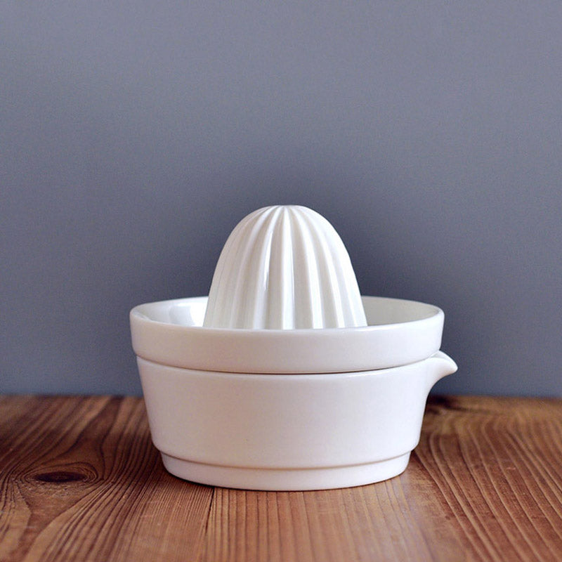 White ceramic manual citrus juicer, perfect for squeezing fresh lemon and orange juice easily at home.