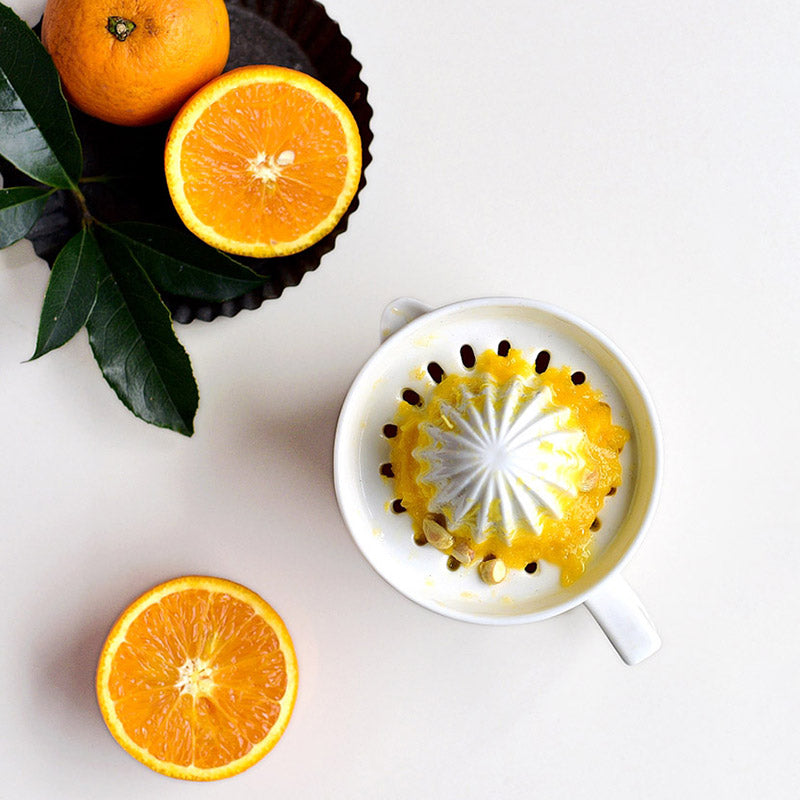 Elegant white ceramic manual citrus juicer. Get fresh lemon & orange juice daily with this easy-to-use tool.