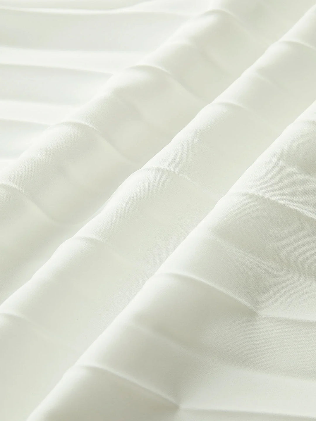 Flowing white strapless maxi dress for women, featuring a beautifully pleated design and modern asymmetric hem.