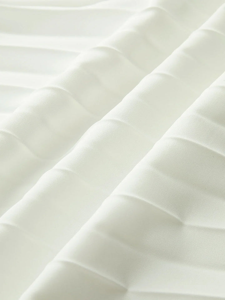 Flowing white strapless maxi dress for women, featuring a beautifully pleated design and modern asymmetric hem.