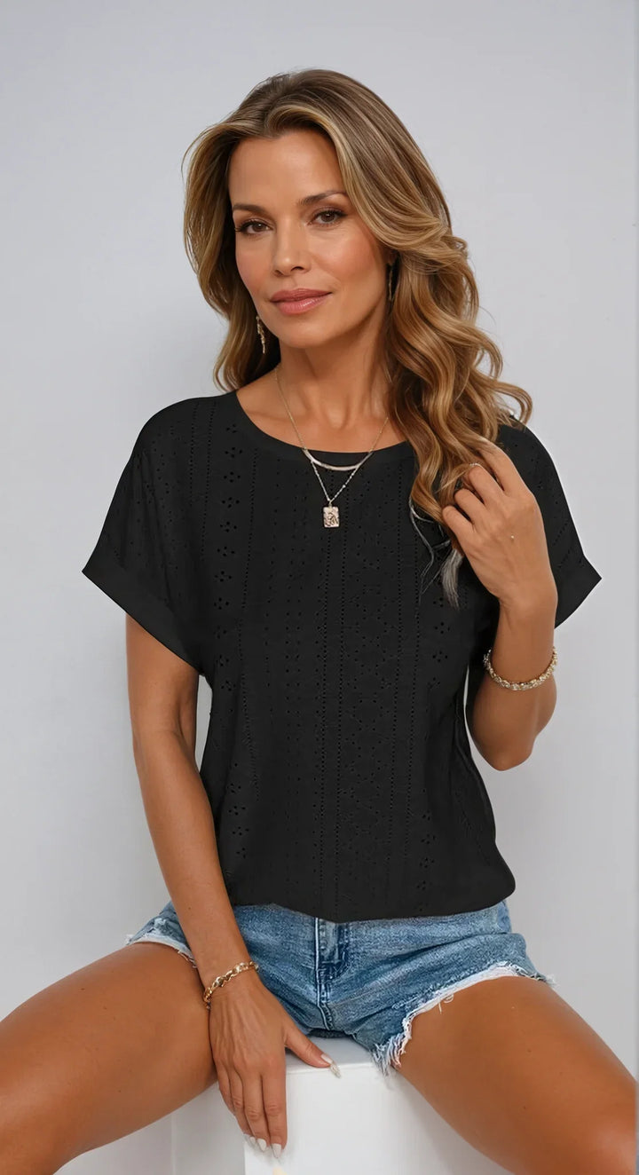 Versatile black eyelet short-sleeve top. Crew neck & cuffed sleeves make it perfect for any occasion.