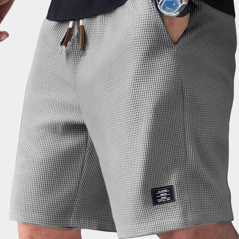 Grey men's waffle knit drawstring shorts. Relaxed fit, textured design for effortless casual style.