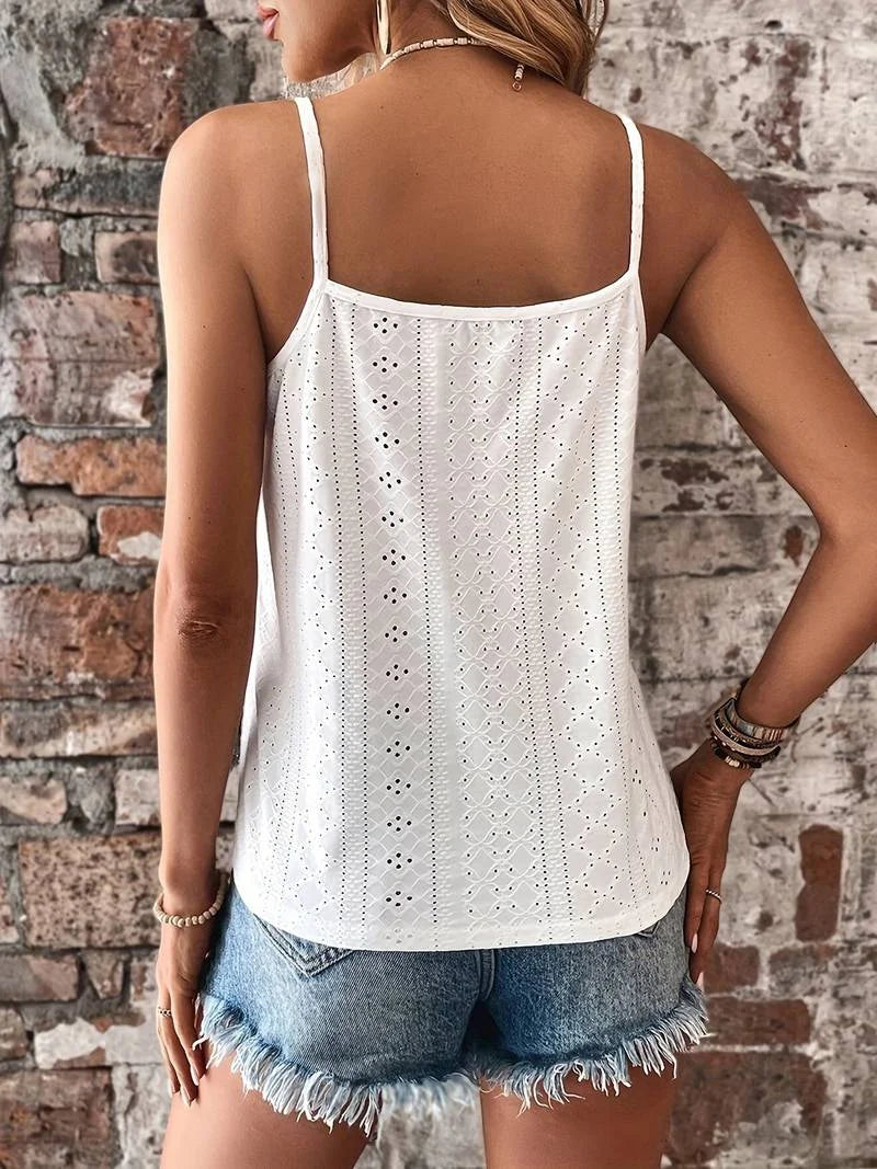 Close-up of white eyelet cami featuring intricate embroidery & elegant V-neck lace trim.