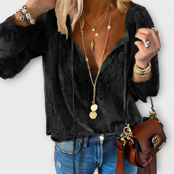 Black sophisticated lace tie-neck blouse for women. Bohemian long sleeve top, perfect for elegant versatile wear.