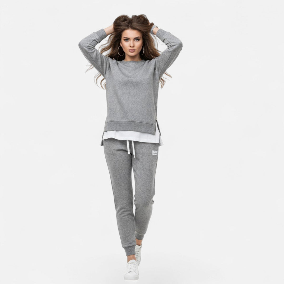 Elegant women's two-piece set featuring a stylish slit sweatshirt & comfortable slim-fit pants. Coordinated fashion.