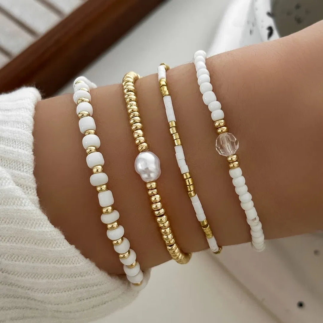 Women's 4-piece gold tone bracelet set with pearl accents. Stackable elegant fashion jewelry.