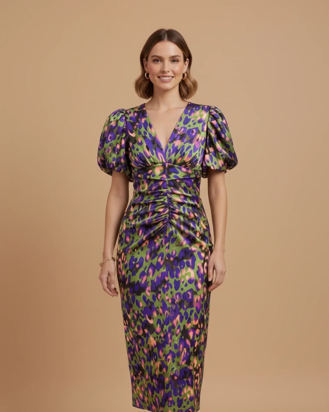 Green animal print fitted midi dress with puff sleeves & V-neck. A fashionable wedding guest outfit.