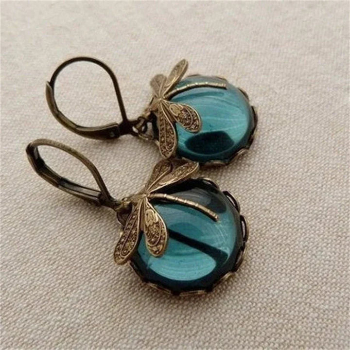 Close-up of elegant antique crystal dragonfly earrings, showcasing intricate wings and sparkling gems.