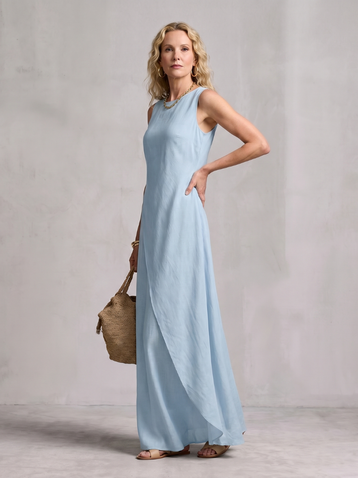 Back view of women's sleeveless asymmetric layered maxi dress, round neck, flowing summer comfort.