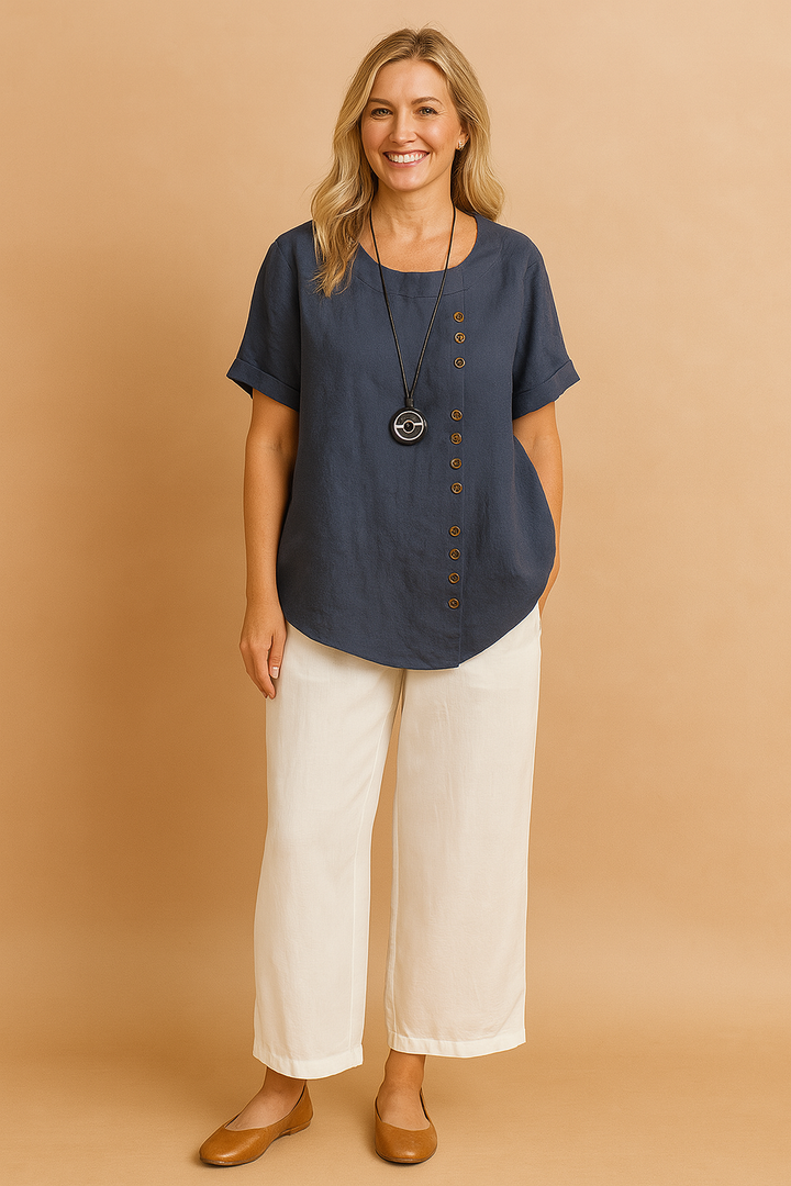 Chic women's fashion blouse. Unique asymmetrical design, short sleeves, and stylish decorative clasp.