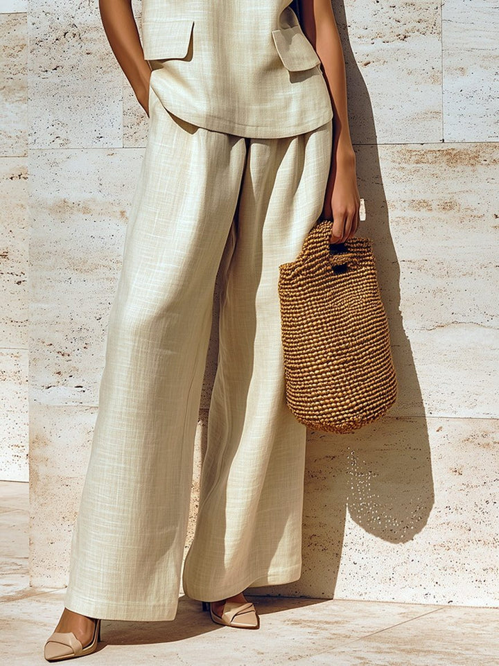 Stylish women's beige linen two-piece set with a sleeveless V-neck vest and relaxed wide-leg trousers.