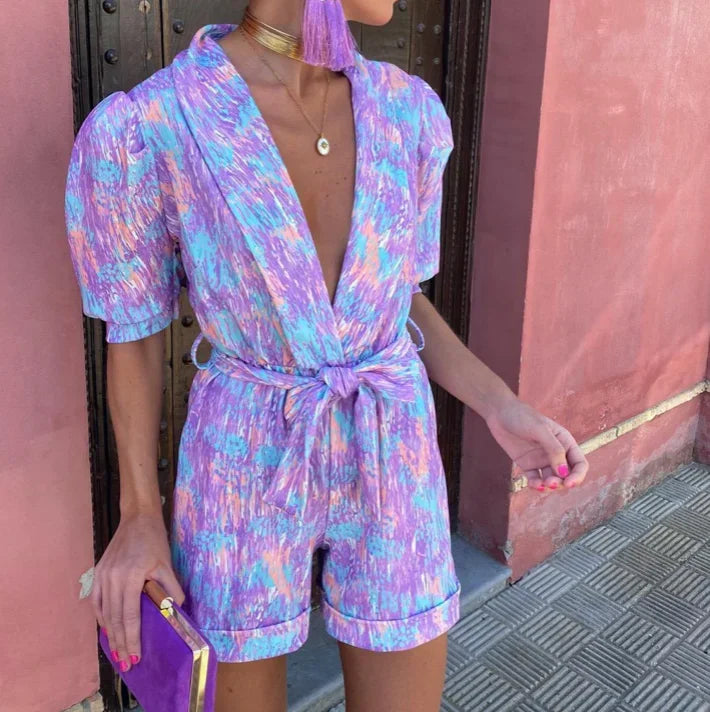Elegant lilac puff sleeve romper with belt, ideal wedding guest attire. Dressy summer party wear.